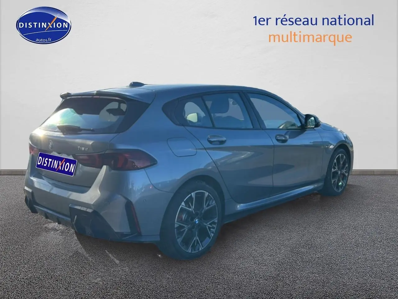 BMW Série 1 gris Skyscraper vue 3/4 arrière droit, avec jantes 18 pouces bicolores et becquet sportif.