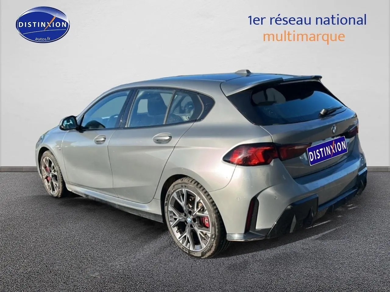 BMW Série 1 118da 2025 gris skyscraper vue 3/4 arrière droit avec jantes bicolores et diffuseur noir.