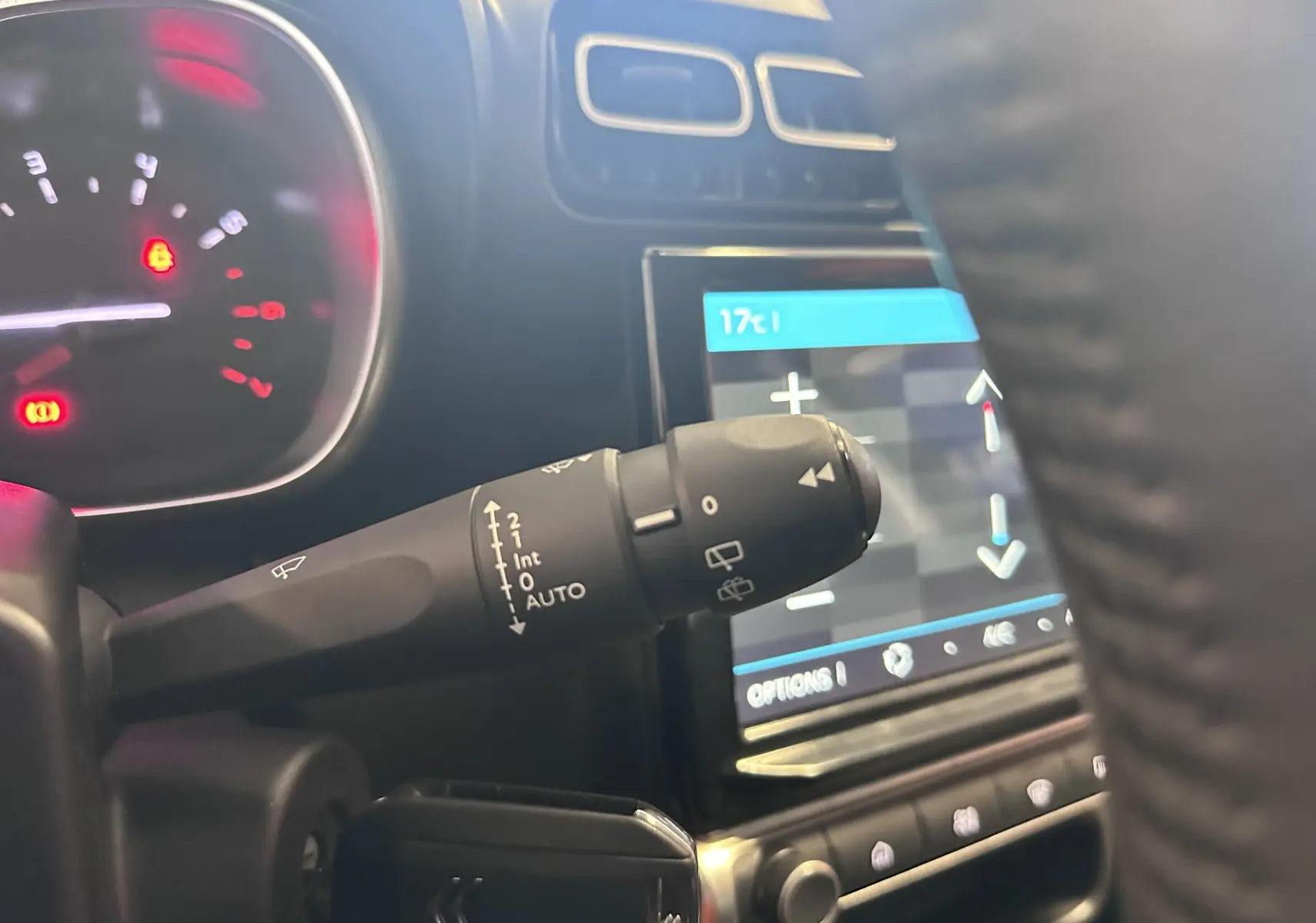Gros plan sur la commande d’essuie-glace à gauche du volant dans l’habitacle d’une Citroën C3 Aircross 2024.