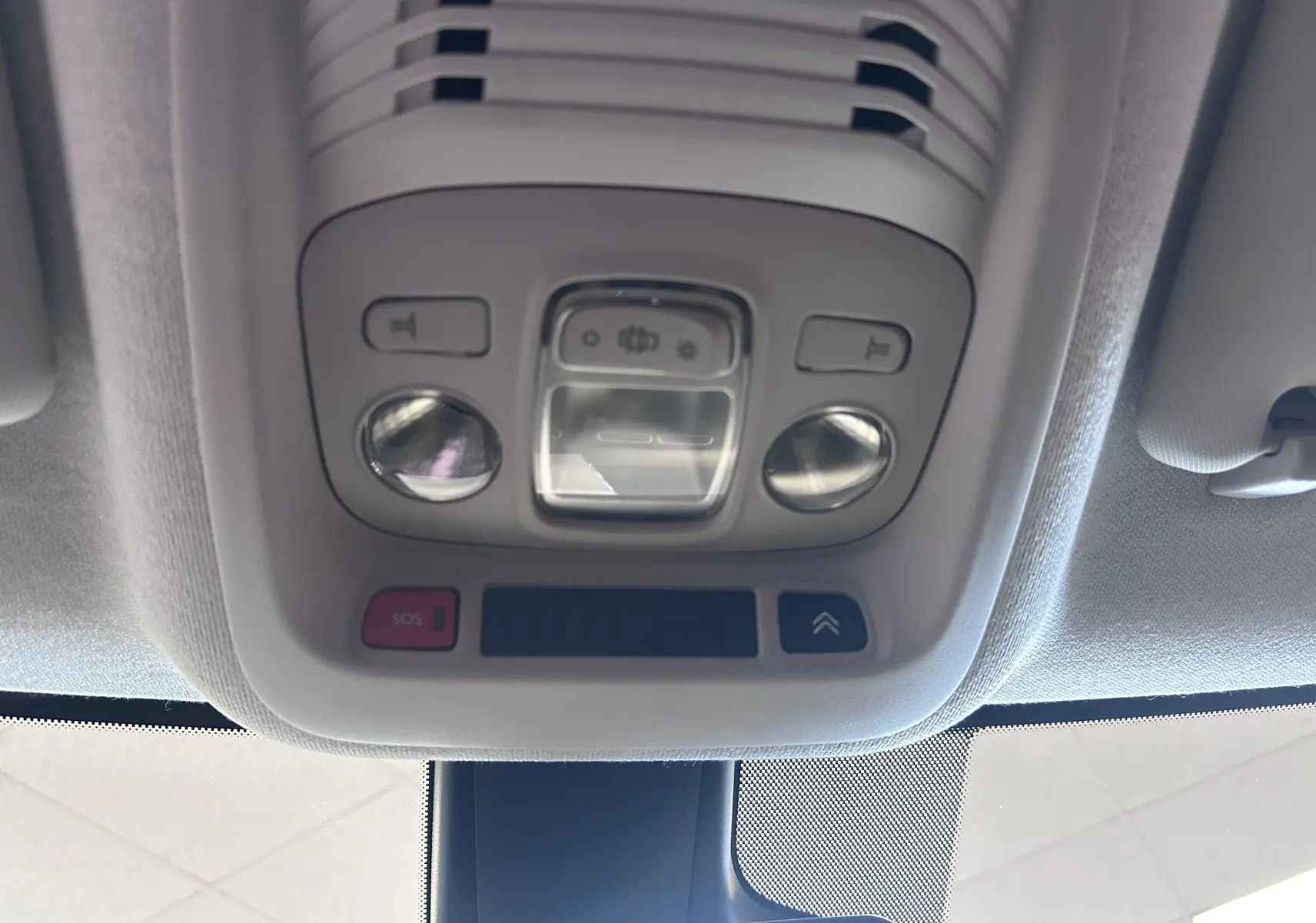 Vue en gros plan du plafonnier intérieur gris clair avec boutons de commande et éclairage du Citroën C3 Aircross 2024.
