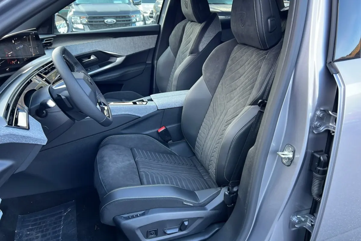 Vue intérieure côté conducteur du Peugeot 3008 Hybrid 145 GT Alcantara gris artense, mettant en valeur les sièges en cuir et alcantara avec réglages électriques.