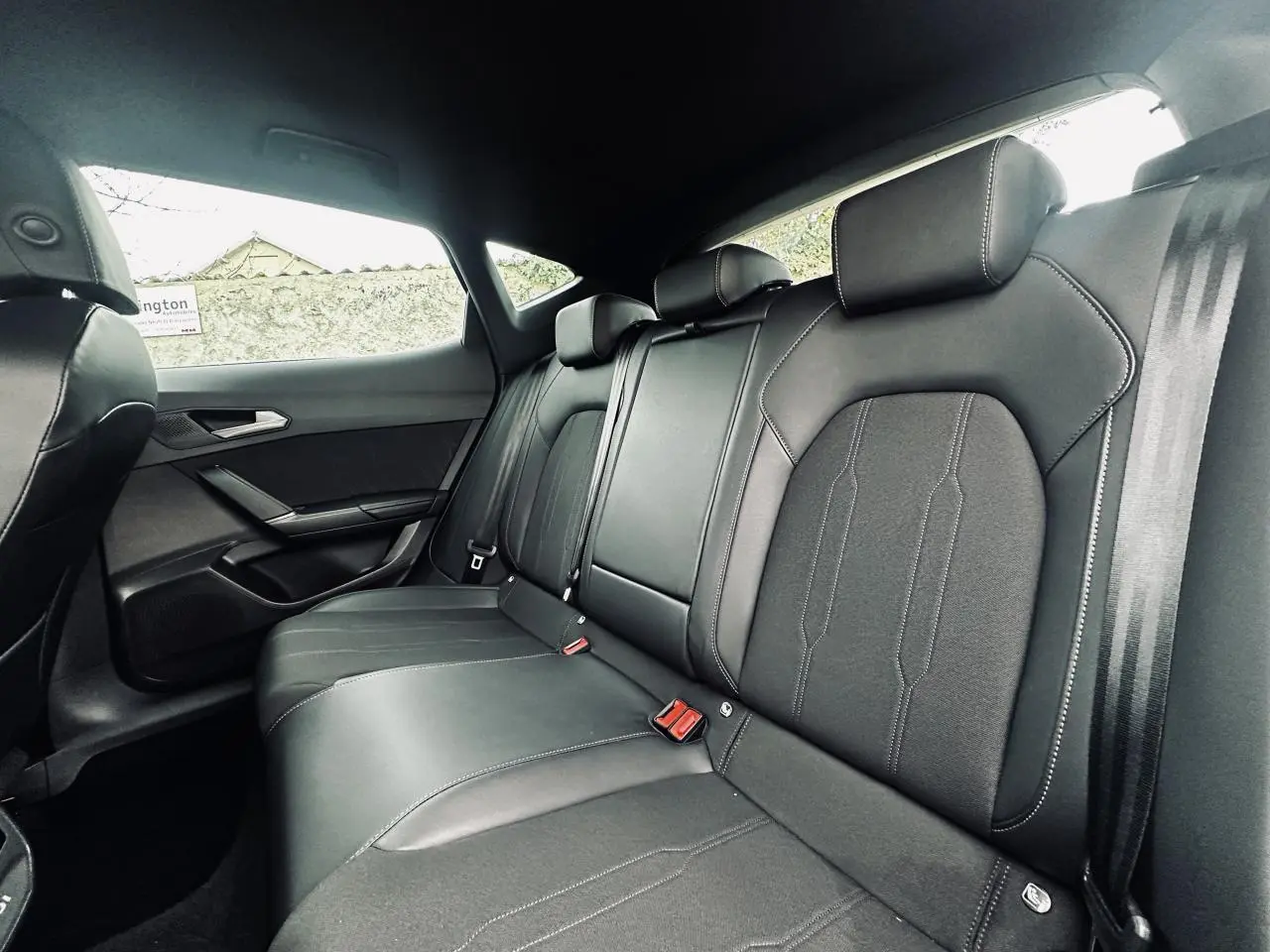 Vue intérieure côté droit des sièges arrière noirs bimatière du CUPRA Formentor 2.0 TDI 2025 avec accoudoir central.