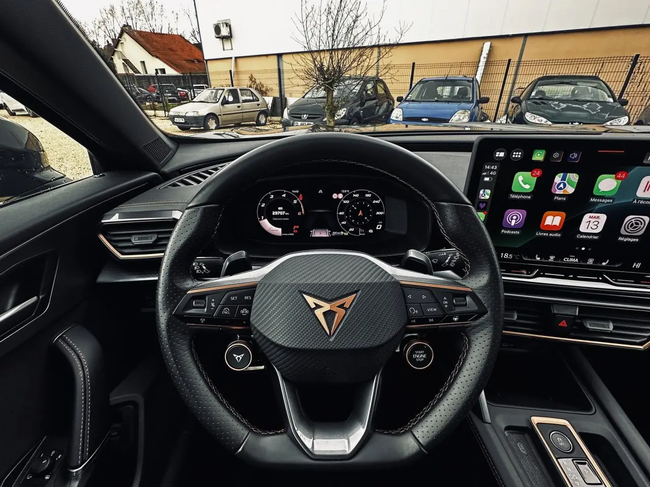 Vue intérieure centrée sur le volant cuir noir perforé avec logo CUPRA et tableau de bord digital du Formentor gris.