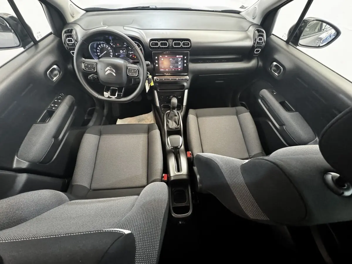Vue intérieure avant de la Citroën C3 gris foncé 2019, avec volant cuir multifonctions et écran tactile central.