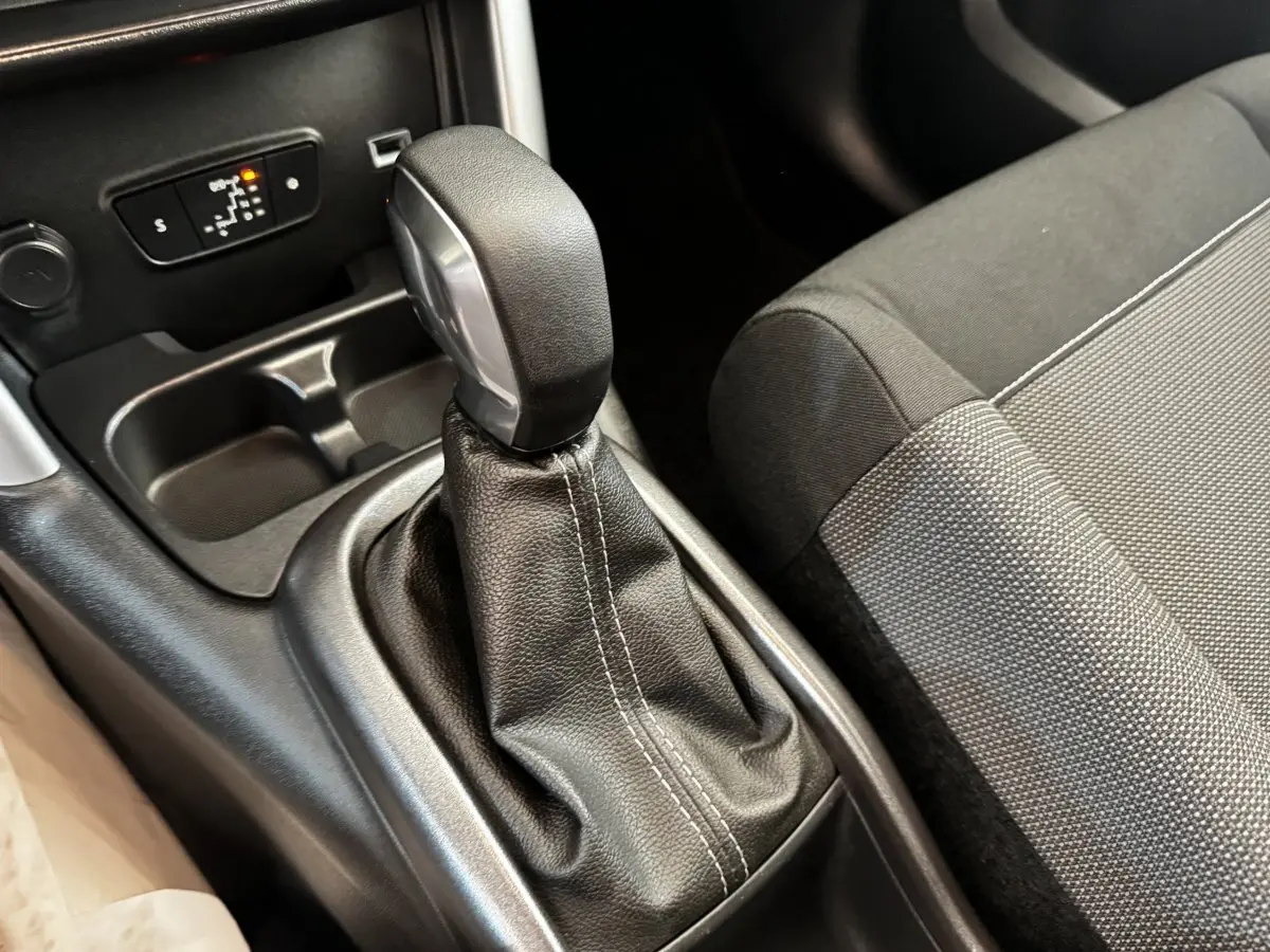 Gros plan sur le levier de vitesses automatique en cuir noir et la console centrale de la Citroën C3 gris foncé.