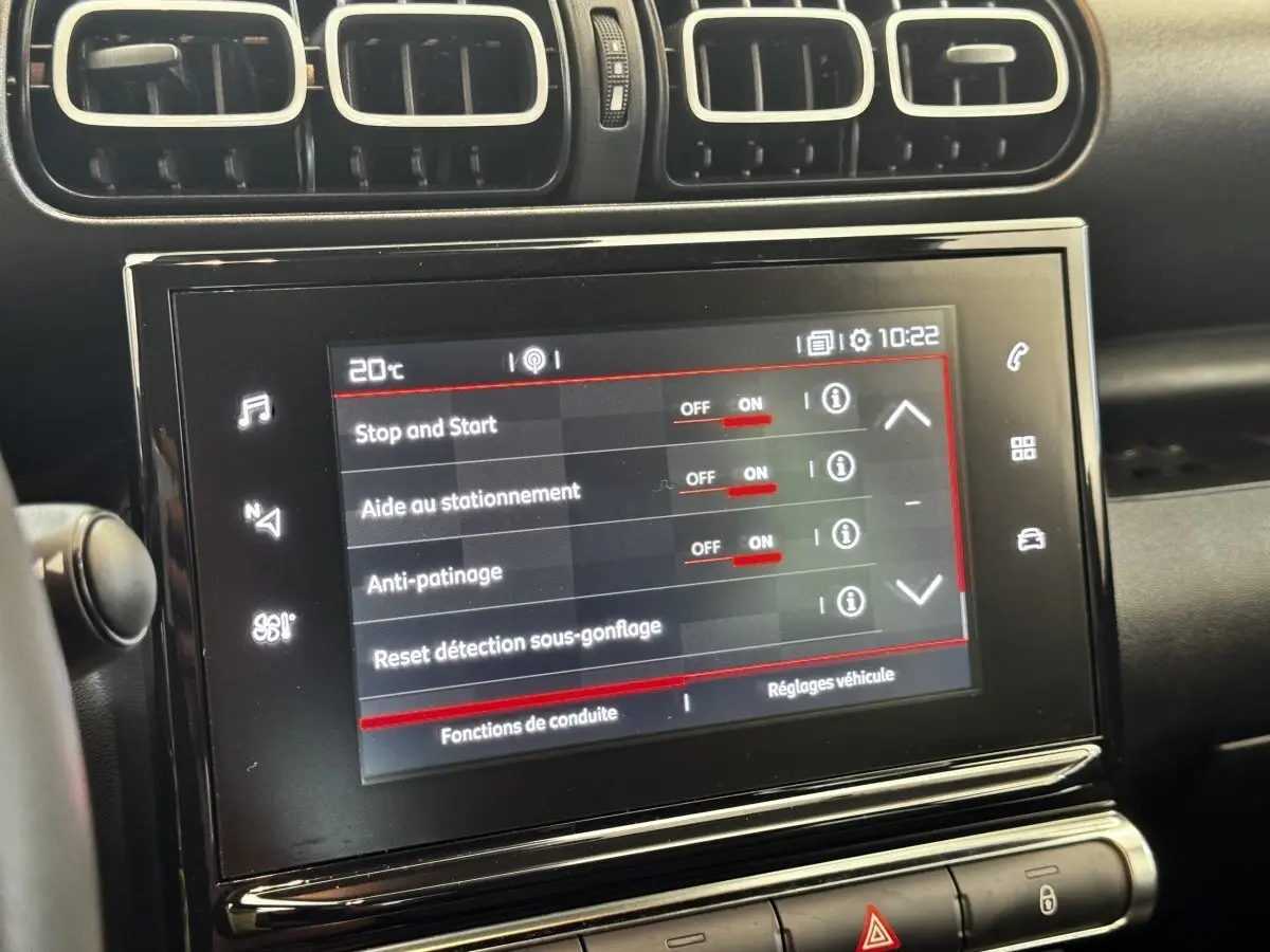 Écran tactile central affichant les réglages d’aide à la conduite dans l’habitacle noir d’une Citroën C3 gris foncé.