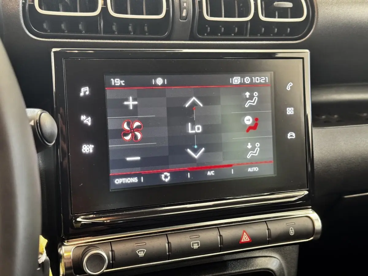 Écran tactile central du tableau de bord d’une Citroën C3 gris foncé, affichant les réglages de climatisation.