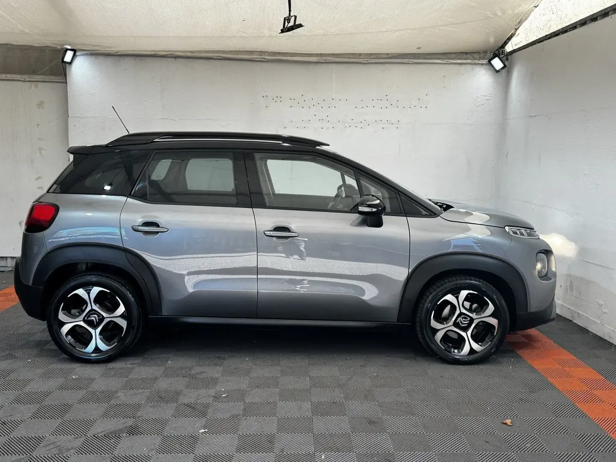 Profil droit d'une Citroën C3 gris foncé 2019 avec toit noir et jantes alliage distinctives en intérieur neutre.
