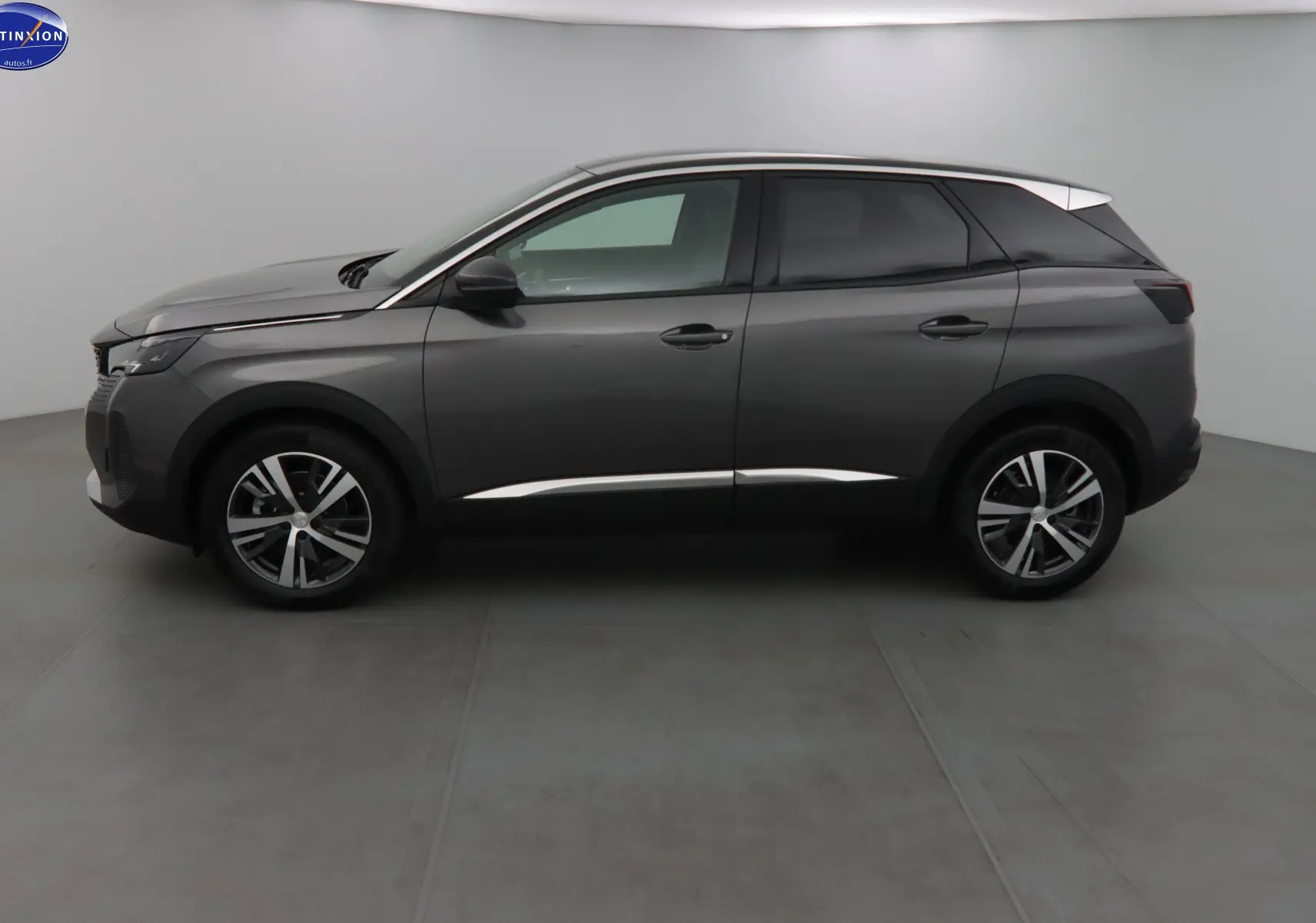 Profil côté gauche d'un Peugeot 3008 gris platinium métal 2023 avec jantes alliage bicolores et toit noir contrasté.