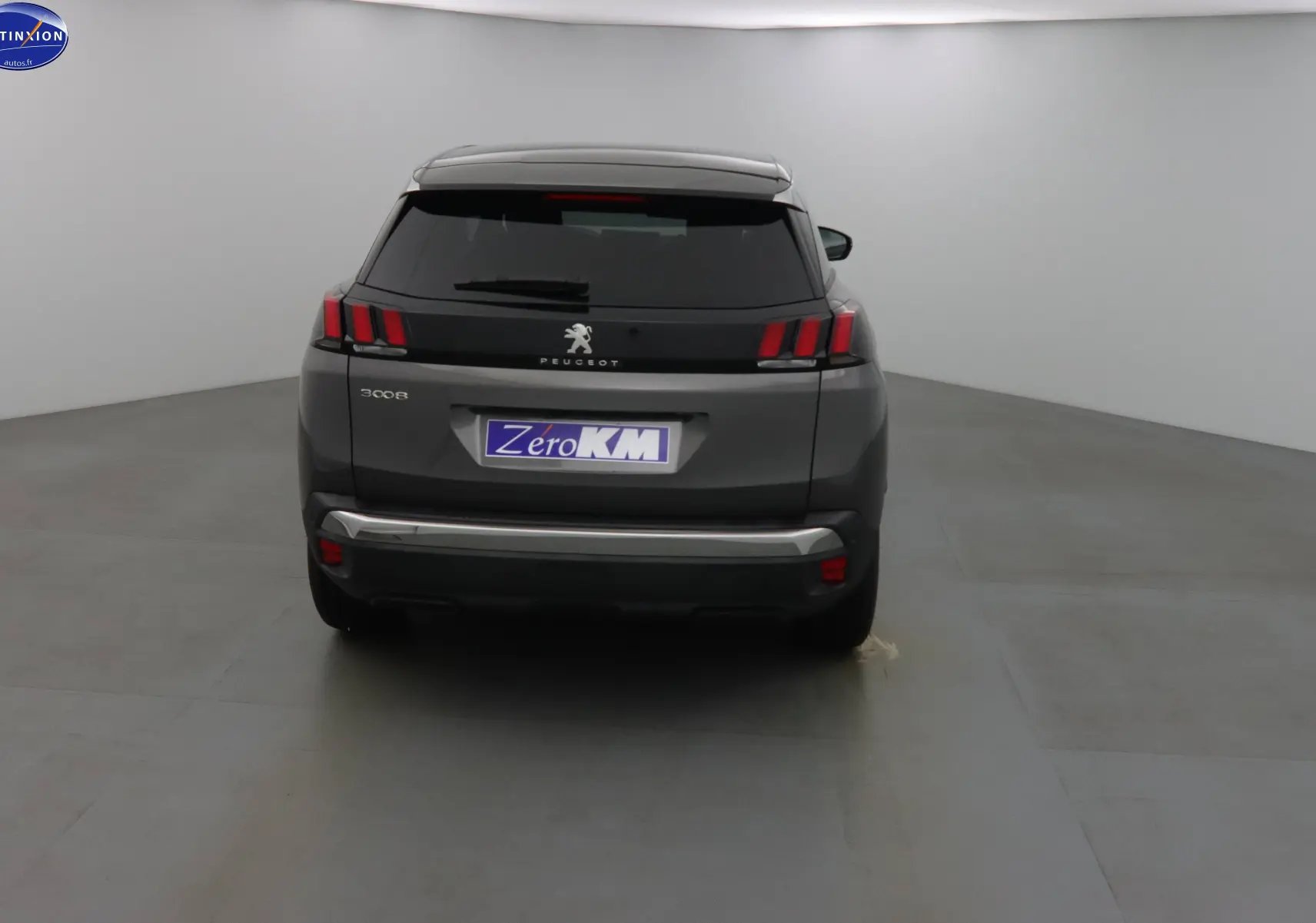 Vue arrière du Peugeot 3008 gris platinium métal 2023 avec feux arrière à griffes et plaque Zero KM.