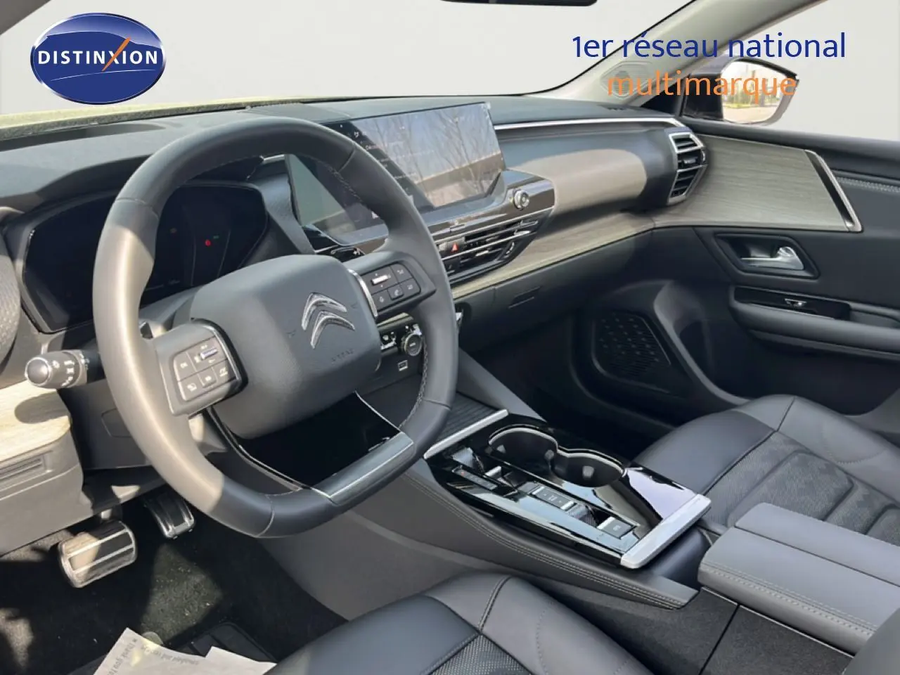 Vue intérieure côté conducteur du Citroën C5 X 2023, tableau de bord moderne avec écran tactile et sellerie cuir noire.