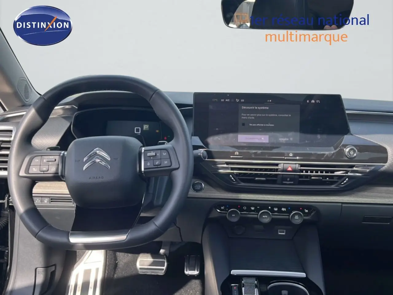 Vue intérieure du tableau de bord et volant noir de la Citroën C5 X 2023 avec écran tactile large et commandes intégrées.