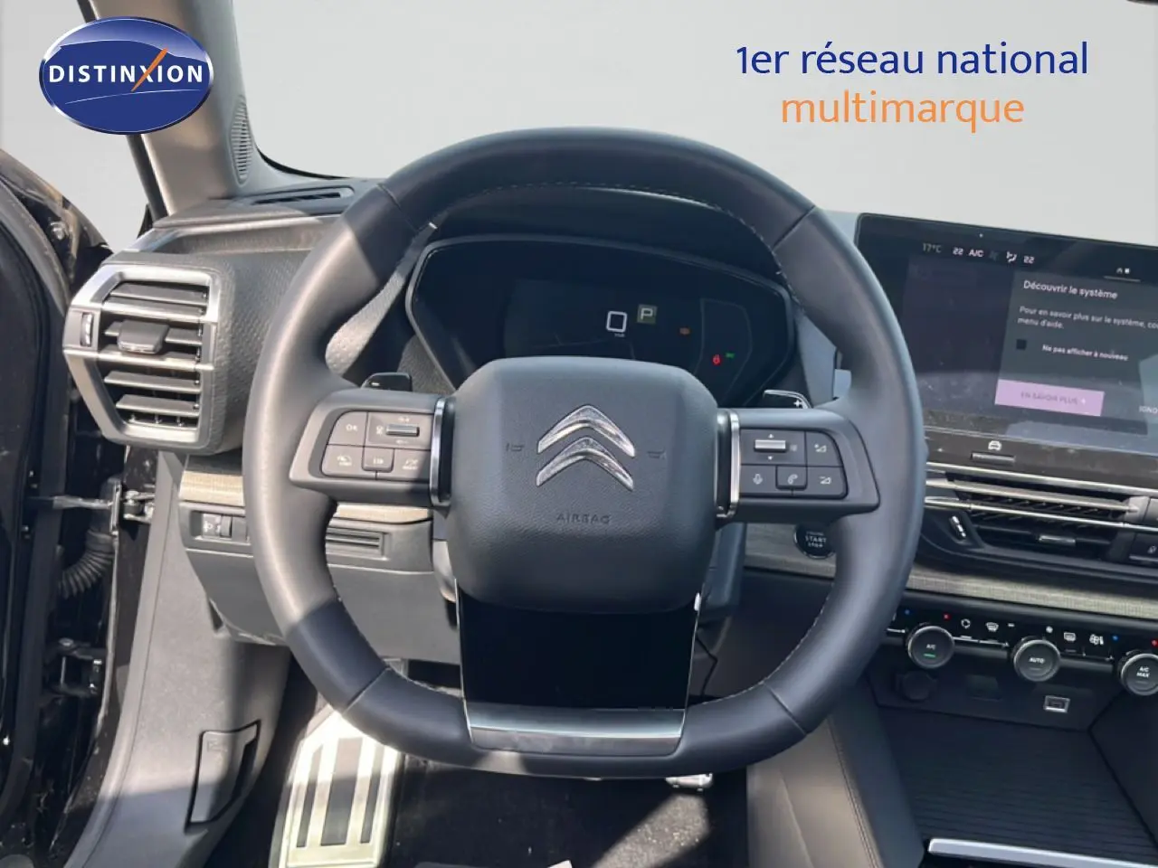 Vue intérieure centrée sur le volant noir du Citroën C5 X 2023 avec tableau de bord et écran tactile visibles.