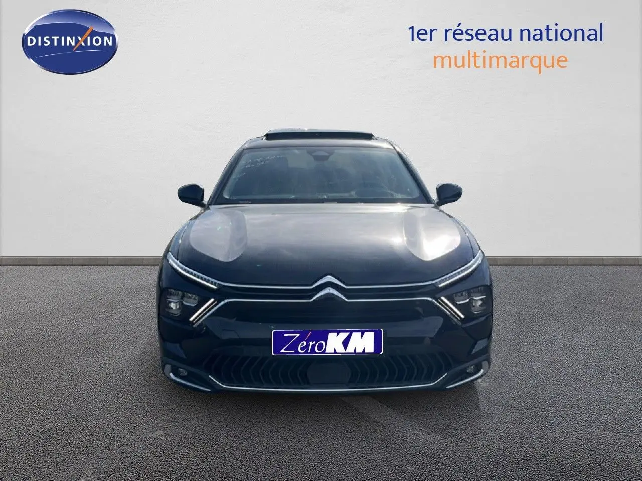 Vue avant d'une Citroën C5 X noire métal 2023 avec signature lumineuse distinctive et calandre moderne.