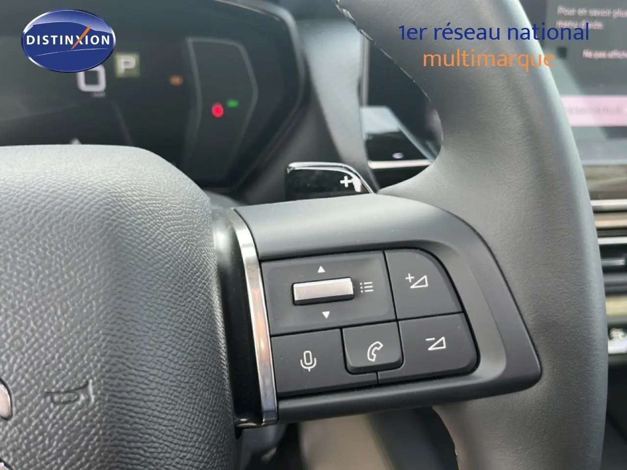 Gros plan sur les commandes au volant du Citroën C5 X 2023 noir métal, avec boutons de volume et téléphone visibles.