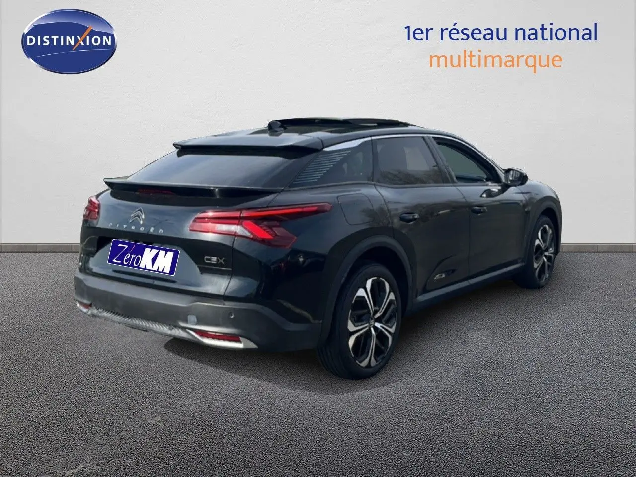 Vue 3/4 arrière droite d'une Citroën C5 X noire métal 2023 avec toit panoramique et jantes bi-ton.