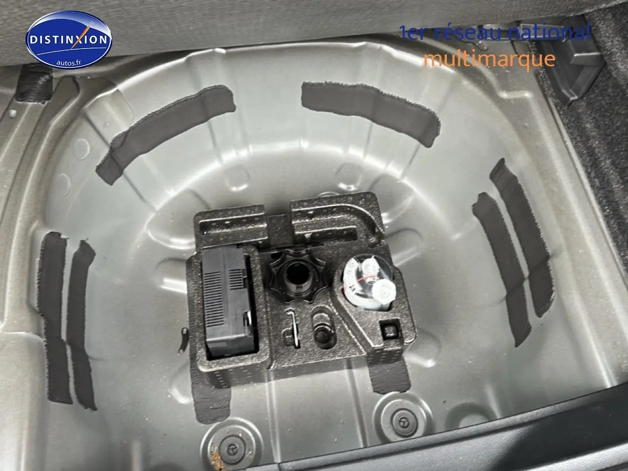 Vue plongeante sur le coffre ouvert d’un SEAT Arona noir minuit, montrant le rangement sous plancher sans roue de secours.