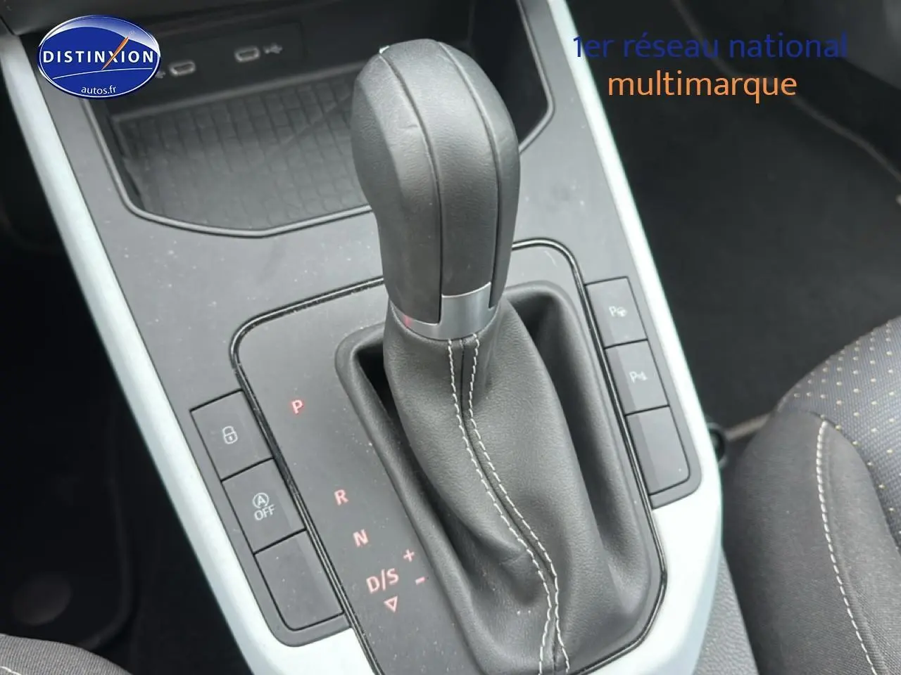 Gros plan sur le levier de vitesse automatique en cuir noir avec coutures blanches, console centrale du SEAT Arona 2025.