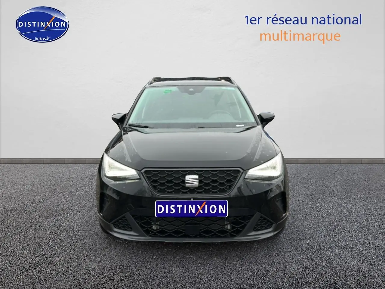 Vue frontale d'un SEAT Arona noir minuit 2025 avec calandre hexagonale et phares LED allumés.