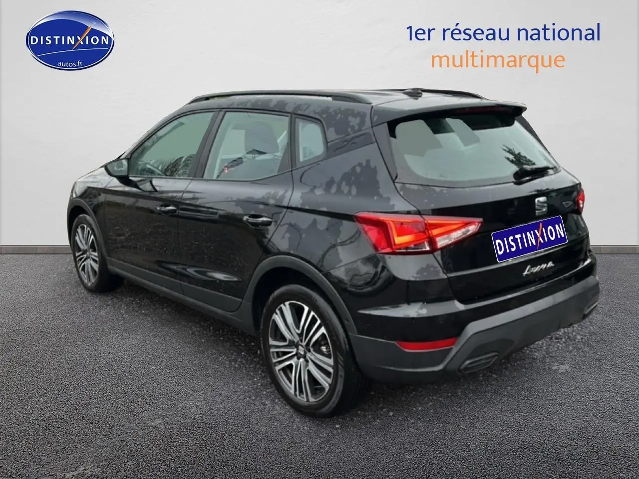 Vue 3/4 arrière droite d'un SEAT Arona noir minuit avec jantes 17 pouces et signature manuscrite sur hayon.