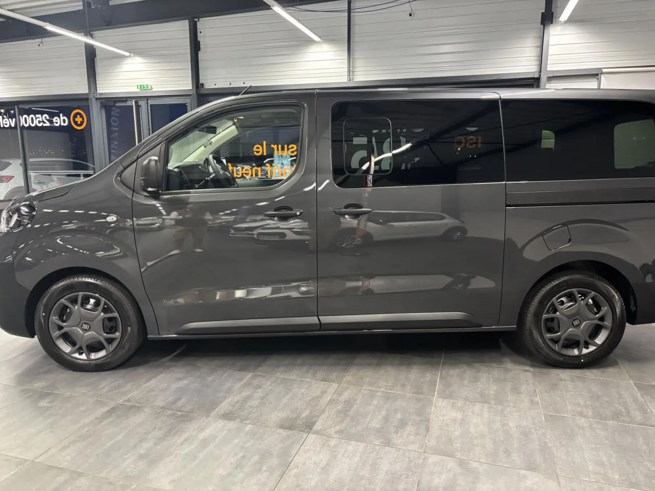 Vue de profil côté gauche du FIAT Scudo Fourgon XL gris foncé avec jantes tôle 17'' noires et vitres latérales teintées.