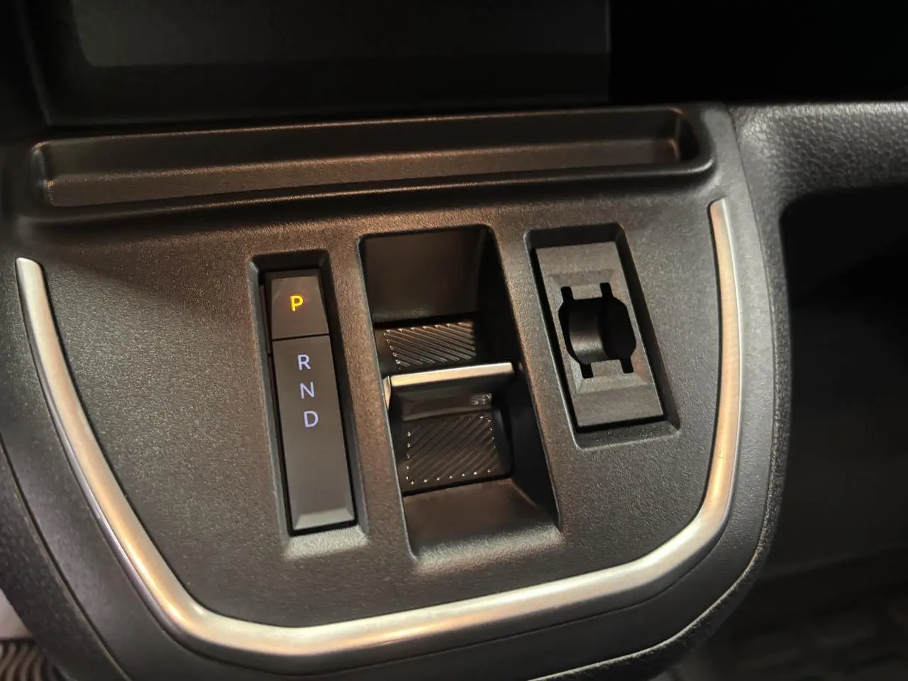 Gros plan sur la commande de boîte automatique noire avec indication P R N D du Fiat Scudo Fourgon gris foncé.