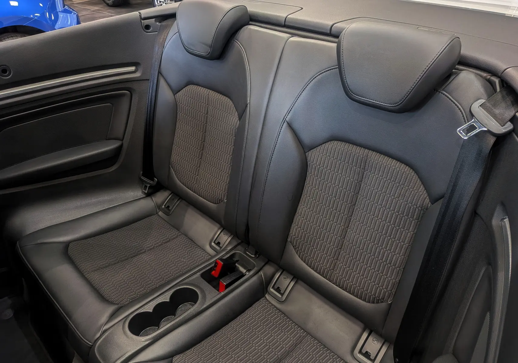 Vue rapprochée des sièges arrière en cuir noir de l'Audi A3 Cabriolet 2017, avec console centrale et ceinture visible.
