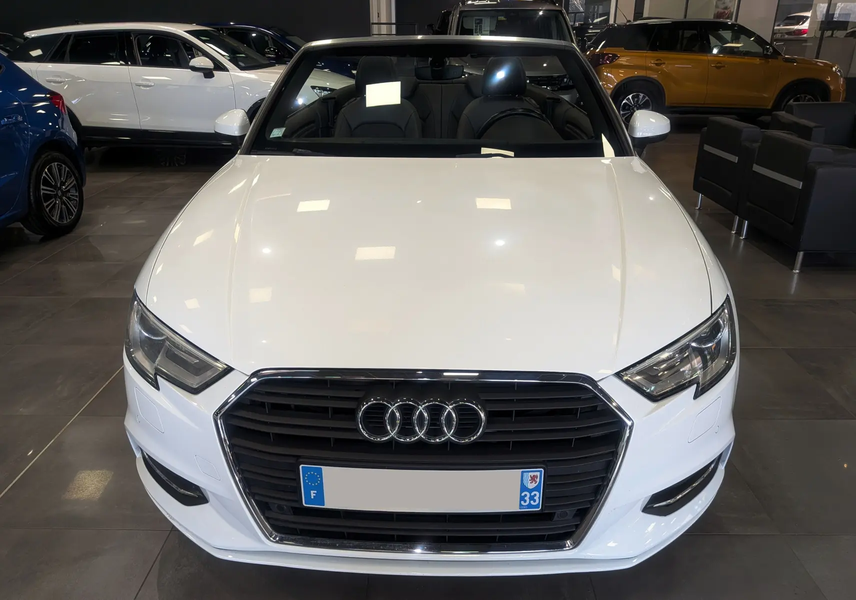 Audi A3 Cabriolet blanc vue 3/4 avant droit, capote ouverte, intérieur cuir noir, en showroom.