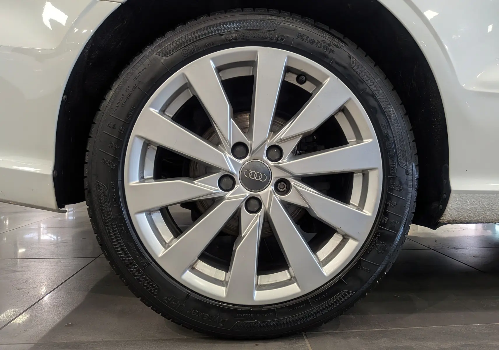 Gros plan sur la roue avant droite d'une Audi A3 Cabriolet blanche de 2017, mettant en valeur la jante en alliage argentée.