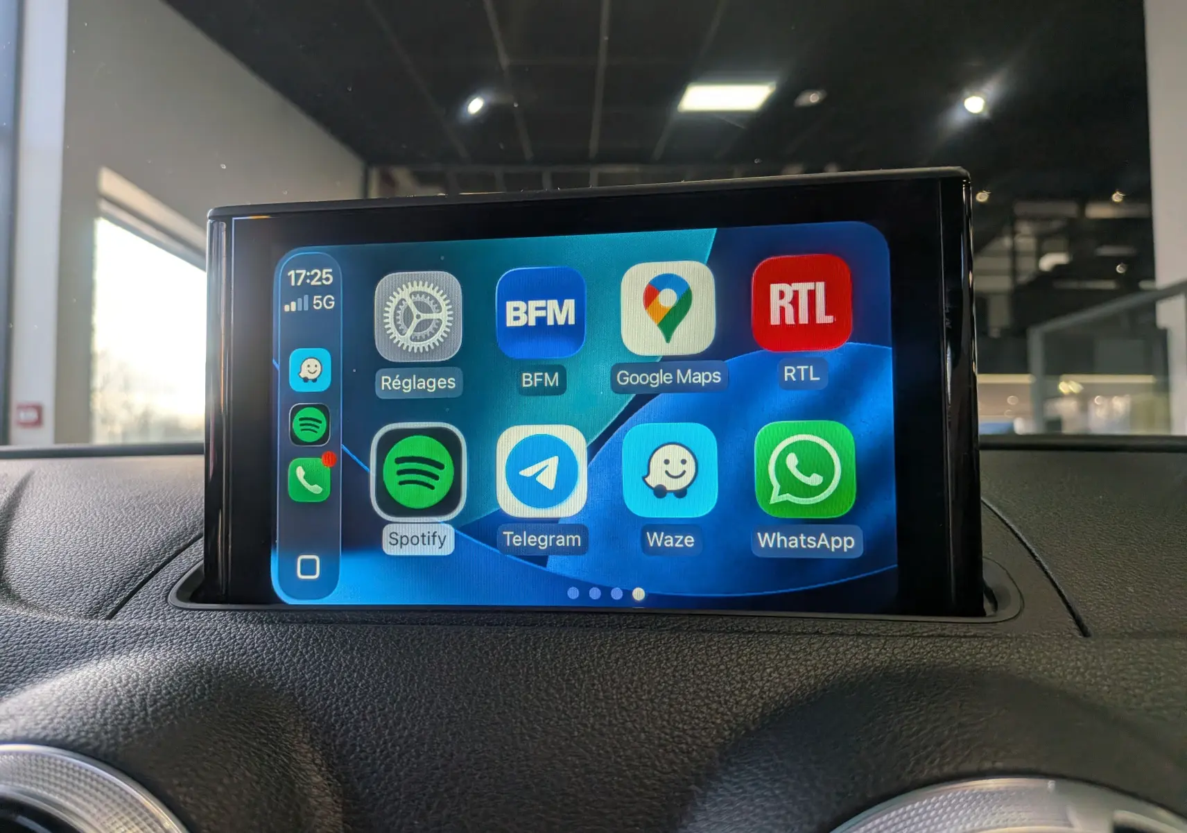 Écran tactile central affichant des applications connectées dans l'habitacle d'une Audi A3 Cabriolet blanc, vue de face.