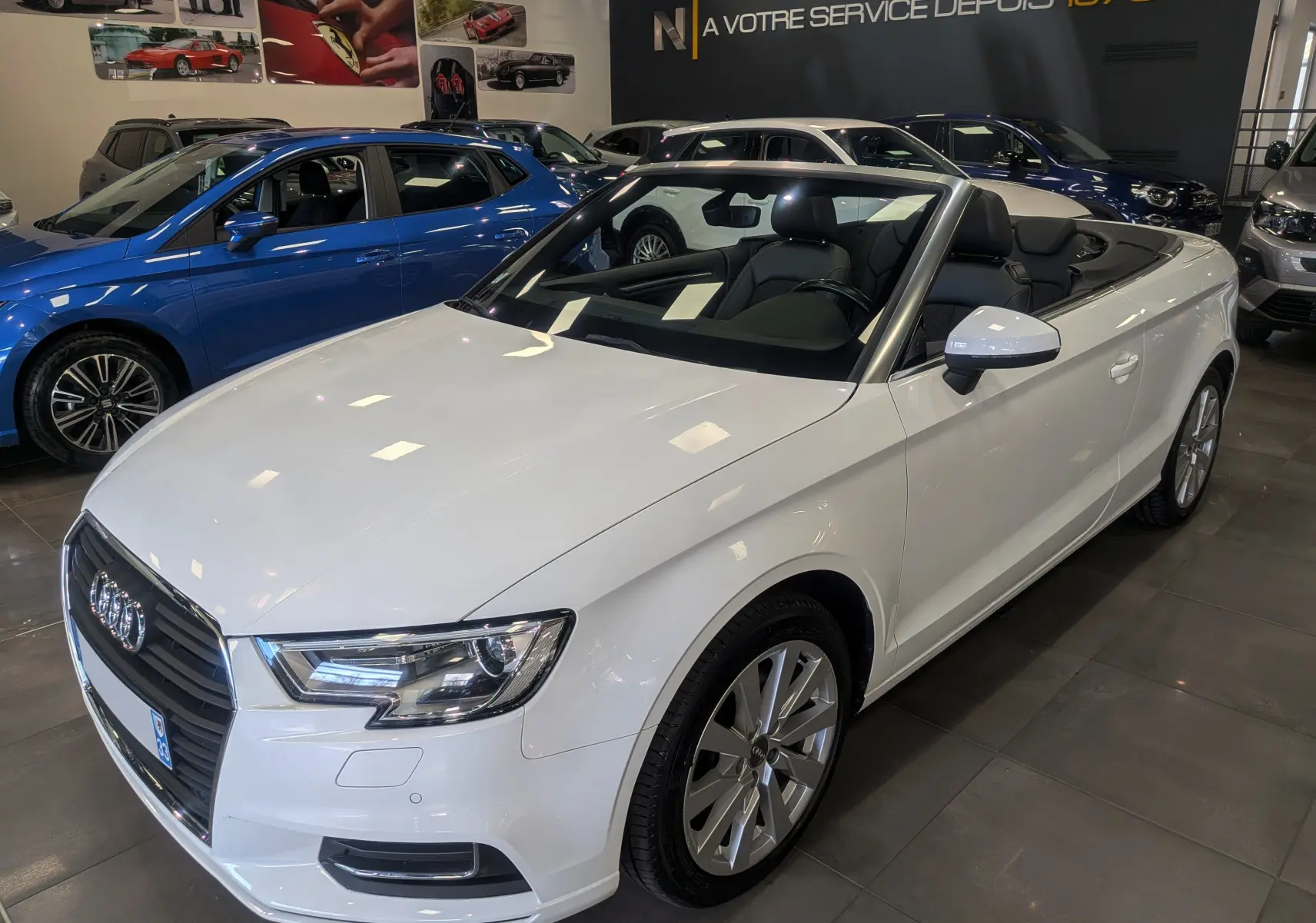 Audi A3 Cabriolet blanc vue 3/4 avant droit, capote ouverte, intérieur noir visible en concession.