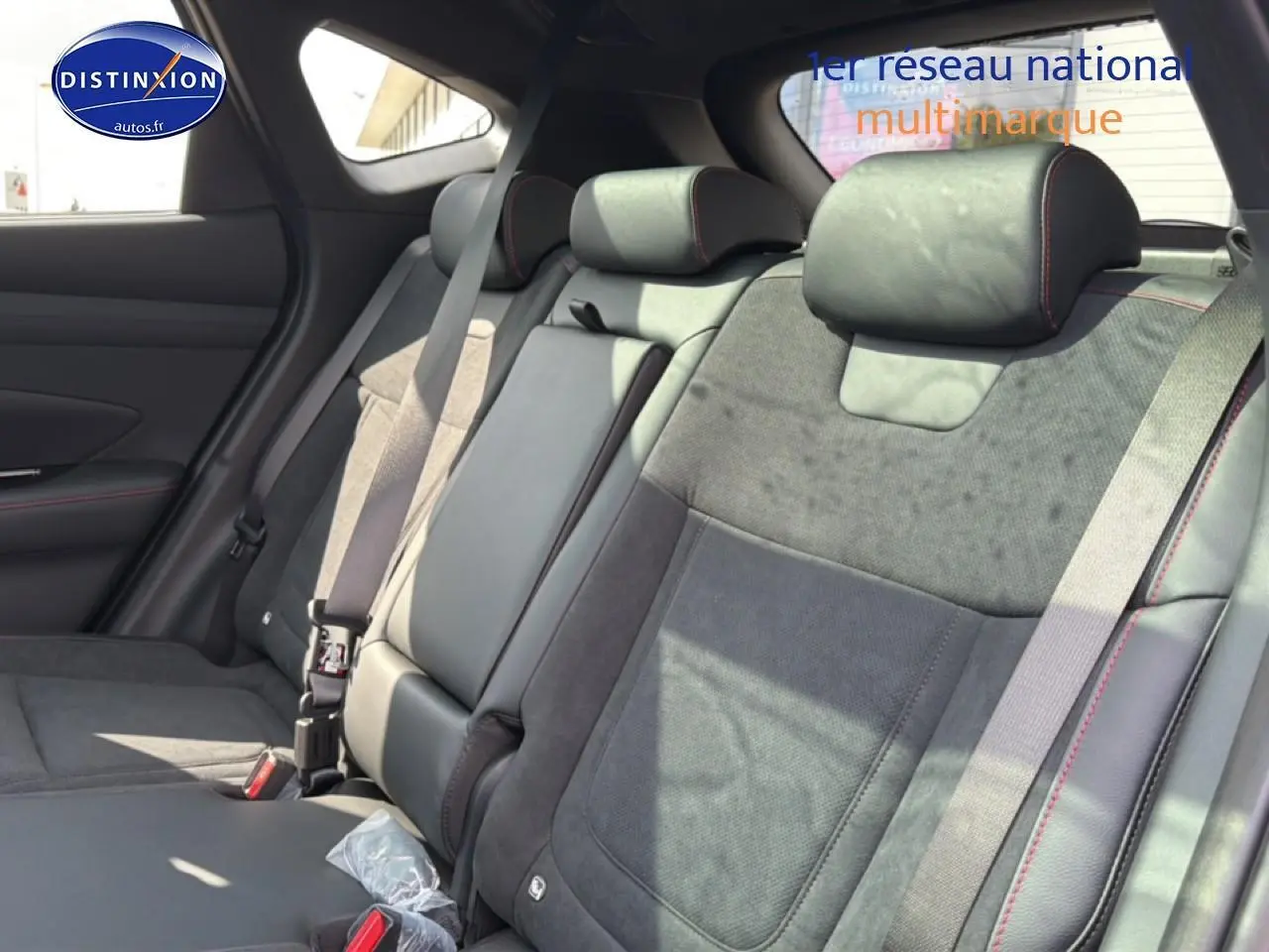 Vue intérieure sur la banquette arrière en cuir noir et alcantara avec surpiqûres rouges du Hyundai Tucson 2026.
