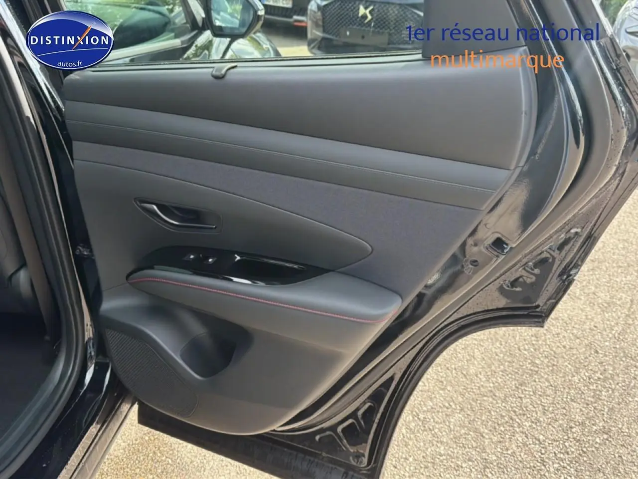 Vue intérieure de la porte arrière droite noire du Hyundai Tucson 2026 avec garniture cuir et surpiqûres rouges.