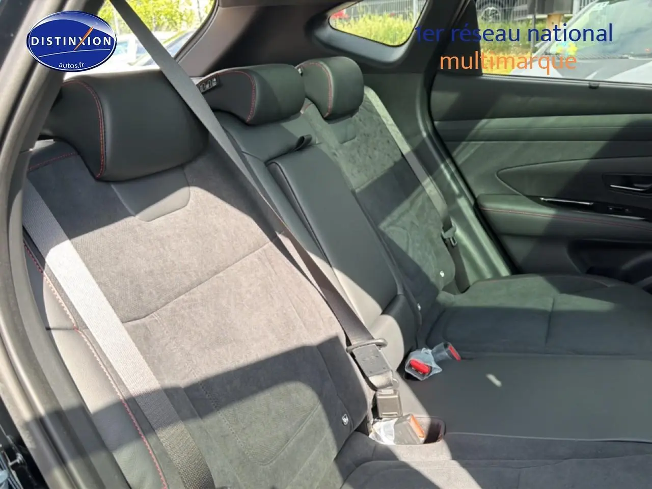 Vue latérale des sièges arrière noirs en cuir et alcantara avec surpiqûres rouges du Hyundai Tucson 2026.