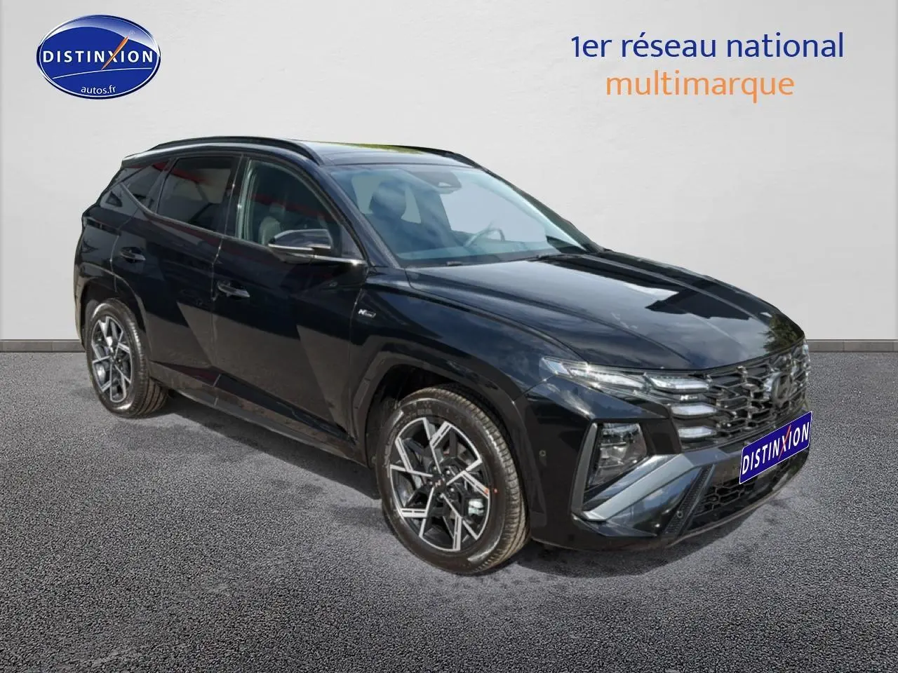 Hyundai Tucson noir en 3/4 avant droit, avec calandre chromée et jantes alu distinctives.