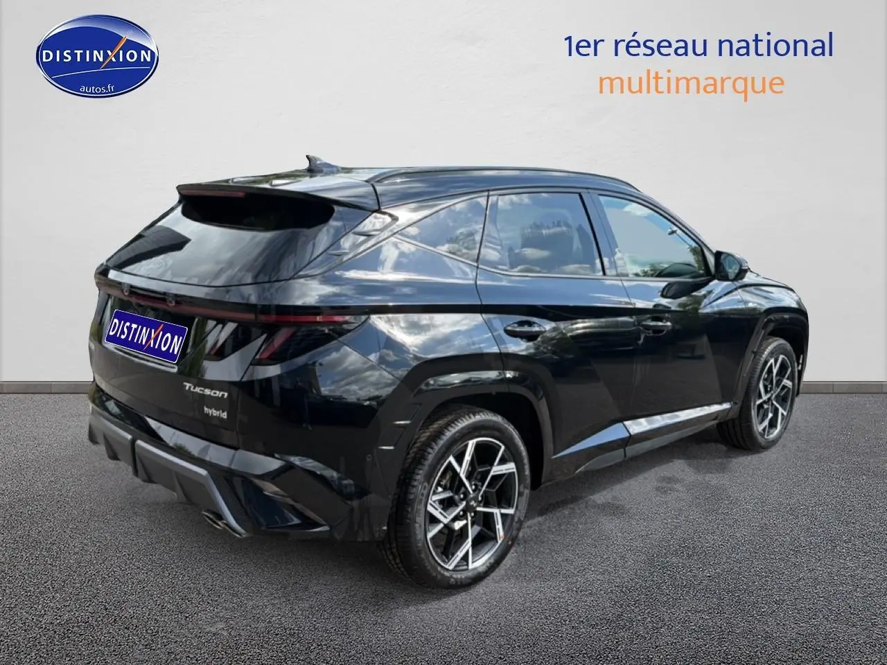 Vue 3/4 arrière droite du Hyundai Tucson noir hybride avec jantes alu et feux arrière LED fins.