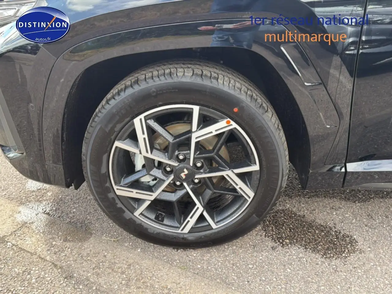 Gros plan sur la roue avant droite noire du Hyundai Tucson 2026 avec jante alu au design géométrique.