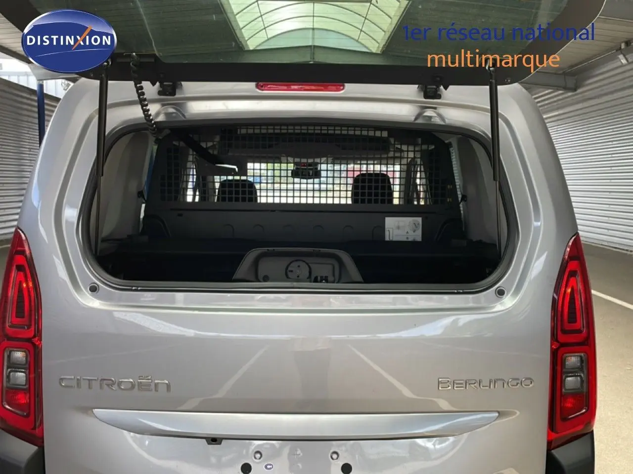 Vue arrière du Citroën Berlingo gris Artense métal 2026 avec hayon ouvert et grille de séparation visible.
