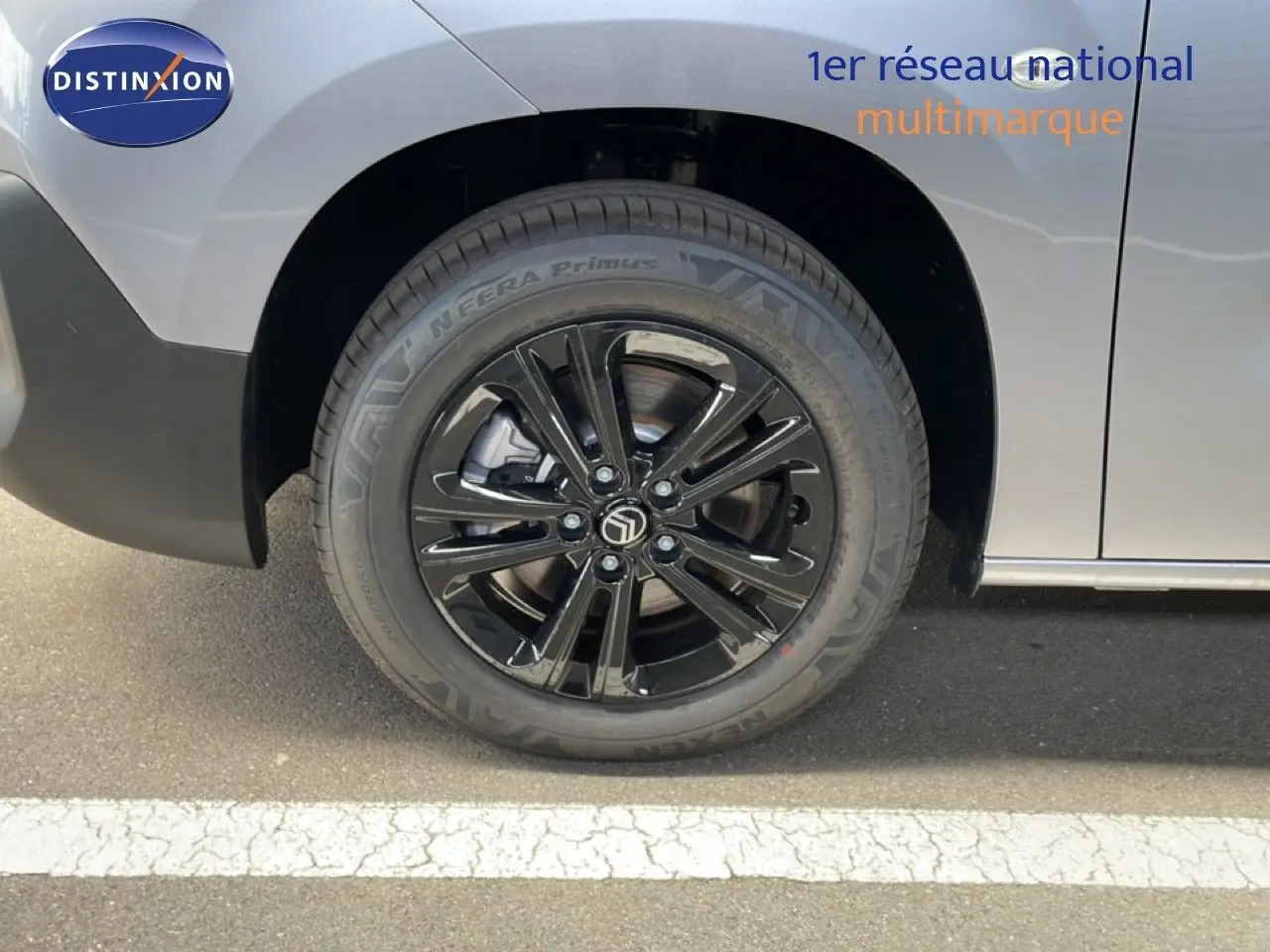 Gros plan sur la roue avant gauche noire brillante du Citroën Berlingo gris Artense Metal 2026.