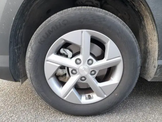 Gros plan sur la roue avant droite du Hyundai Kona 2024 Mirage Green avec jante alliage argentée et pneu Kumho.