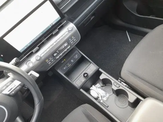 Vue intérieure du tableau de bord et console centrale du Hyundai Kona 2024, finition Intuitive avec écran tactile et commandes climatisation.