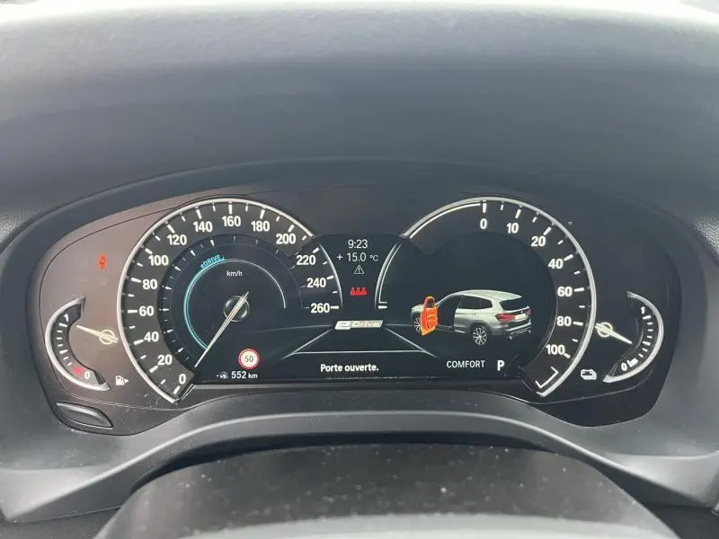 Tableau de bord numérique BMW X3 xDrive30e 2020 montrant porte ouverte et affichage vitesse, température et mode confort.