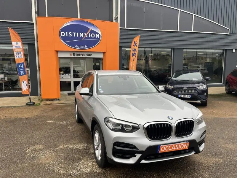 BMW X3 xDrive30e 2020 glaciersilber en 3/4 avant, avec calandre noire et plaque "OCCASION" orange visible.