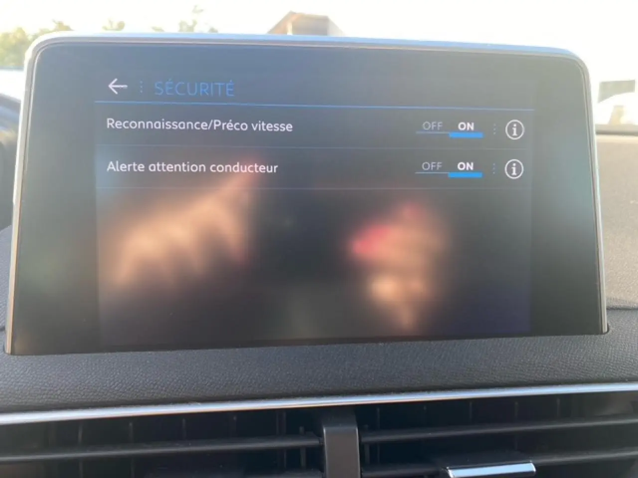 Écran tactile du tableau de bord du Peugeot 3008 beige clair affichant les réglages de sécurité activés.