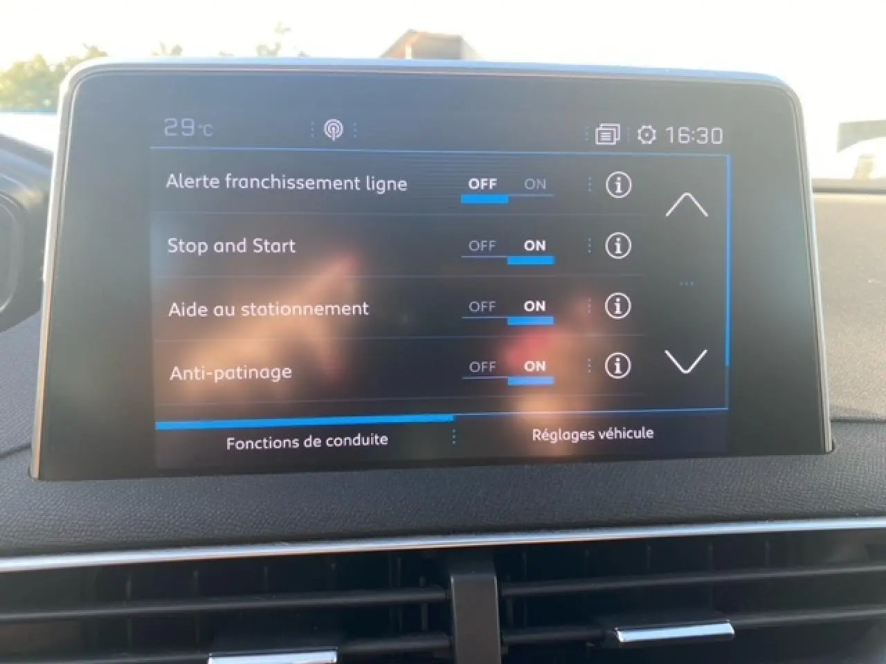 Écran tactile central du Peugeot 3008 beige clair affichant les réglages d’aides à la conduite en intérieur.