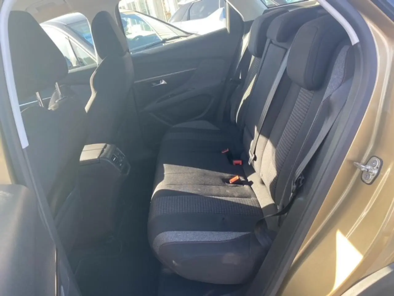 Vue intérieure côté arrière droit du Peugeot 3008 beige clair, montrant les sièges arrière en tissu et la portière ouverte.