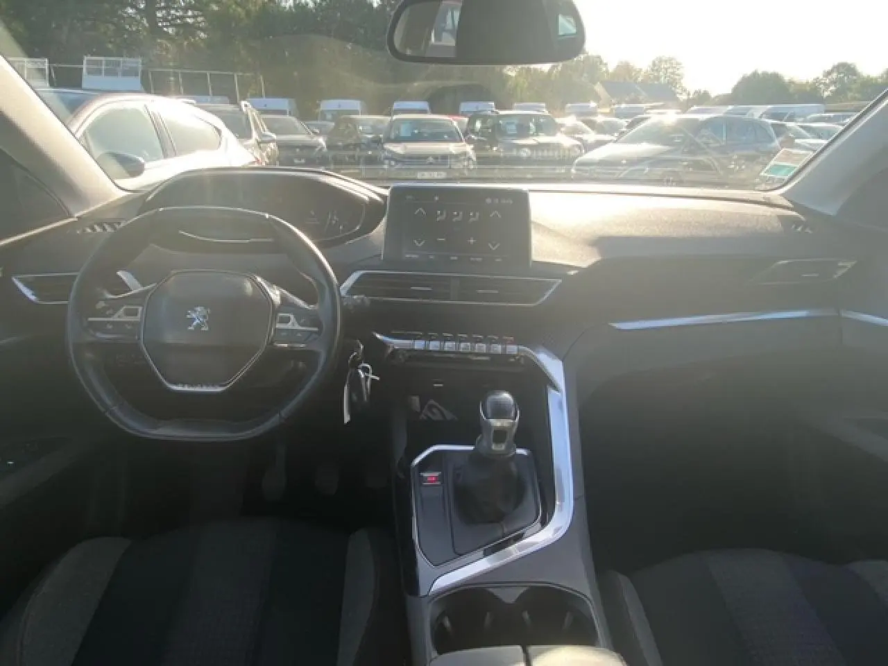 Vue intérieure avant du Peugeot 3008 beige clair, mettant en valeur le volant compact, la boîte manuelle et l'écran tactile central.