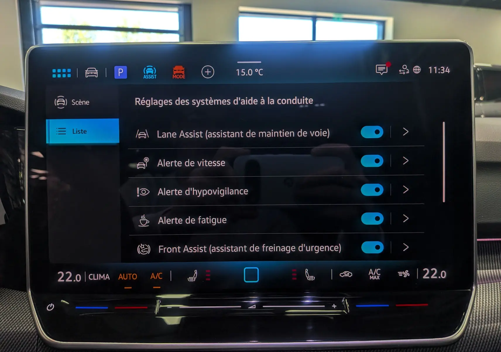Écran tactile central intérieur de la Volkswagen Golf VIII gris Urano, affichant les réglages d’aides à la conduite.