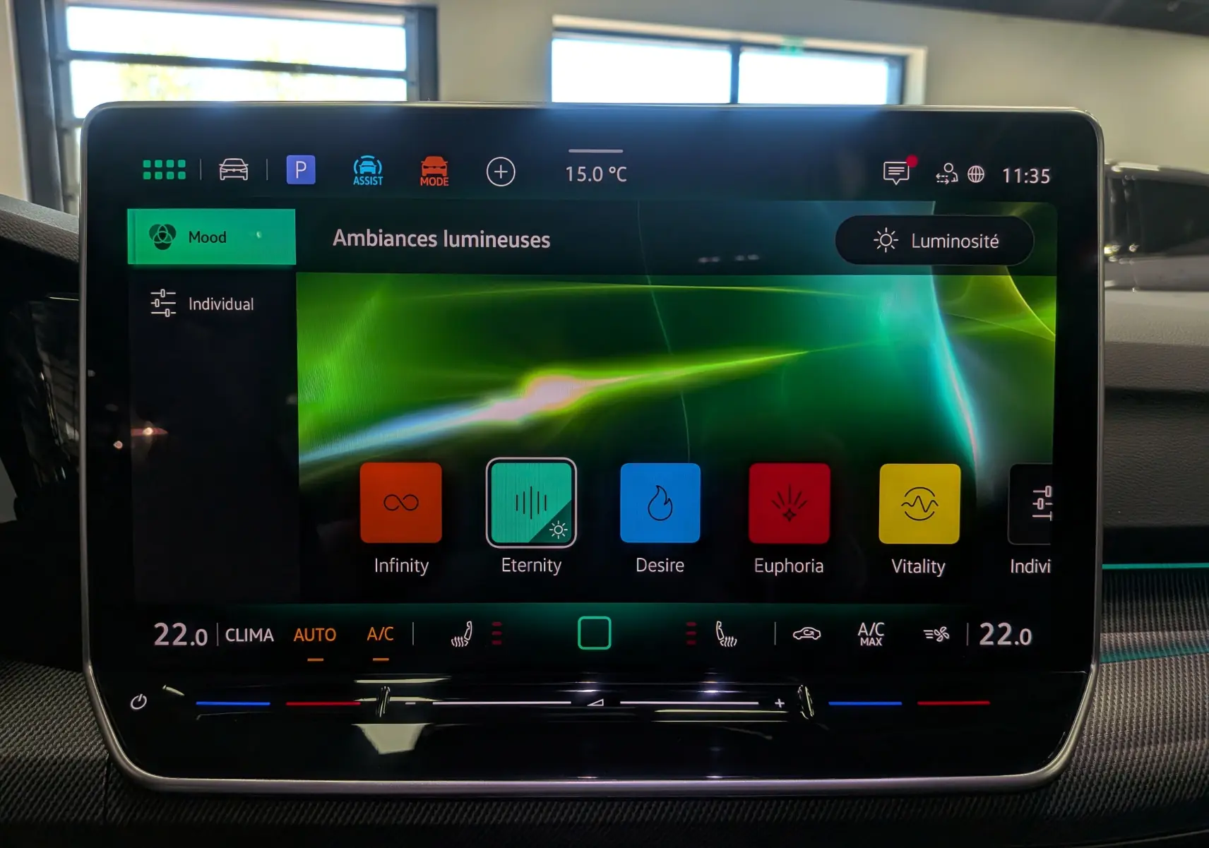 Écran tactile central de la Volkswagen Golf VIII 1.5 eTSI R-Line affichant les ambiances lumineuses avec réglage de la climatisation.