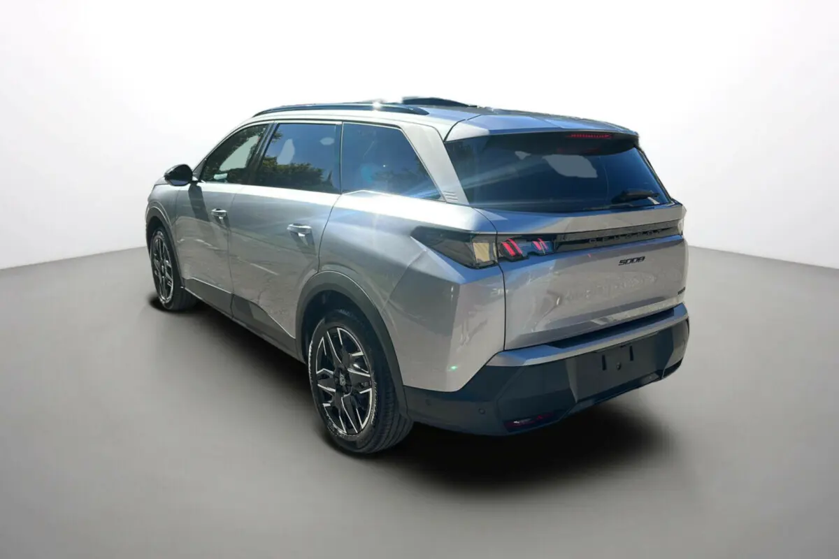 Vue 3/4 arrière droite du Peugeot 5008 Hybrid 145 Allure Plus gris Artense avec jantes alu 19 pouces et feux LED distinctifs.